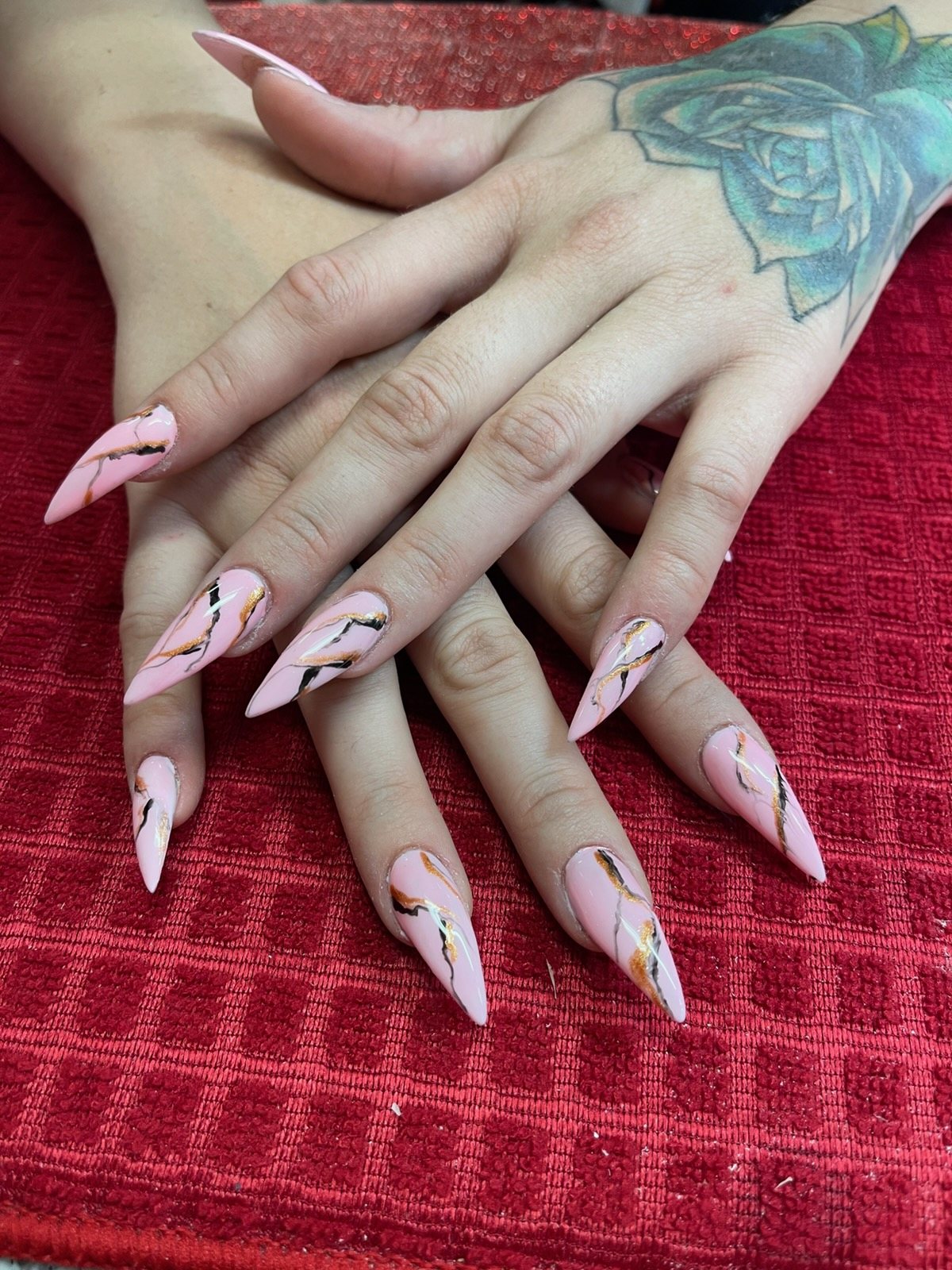 Pink marble nail design with gold and black accents by Velour Nails Studio
